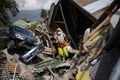 A woman makes her way through rubble in the Palu neighborhood of Balaroa on October 2.jpg