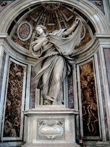 This statue shows the saint as a young woman, who, with a sweeping dramatic gesture, displays a cloth on which there is an image of the face of Jesus.