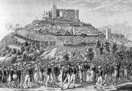 رجال ونساء يمشون نحو أنقاض قلعة في أعلى التلة