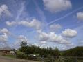 Decaying contrails over a military airbase before an airshow