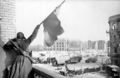 A Soviet soldier waving a flag in victory at the Battle of Stalingrad, the largest, deadliest battle in history.