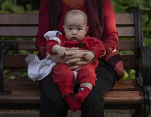 شابة صينية تحمل طفلها.jpg