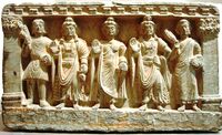 Early Mahayana Buddhist triad. From left to right, a Kushan devotee, Maitreya, the Buddha, Avalokitesvara, and a Buddhist monk. 2nd–3rd century, Gandhara.