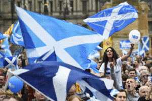اسكتلنديون مؤيدون للانفصال عن المملكة المتحدون يلوحون بعلم اسكتلندا أثناء استفاء الاستقلال الاسكتلندي 2014.GIF