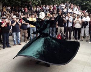 Whirling Sufi Protester wearing gas mask in a Gezi Protest in Ankara.jpg