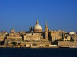 Coastal city with churches and a large dome.