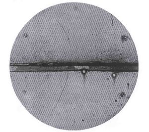 track of subatomic particle moving upward through cloud chamber and bending left (an electron would have turned right)