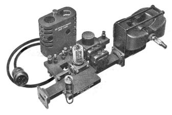 تجميع جهاز الإرسال بقوة 20 كيلووات ، 9.37 GHz التحكم في الحركة الجوية الرادار ، 1947. ينتج magnetron الأنبوب المركب بين مغناطيسين (يمين) أمواج ميكروية تمر من الفتحة (يسار) إلى الدليل الموجي الذي ينقلهم إلى هوائي الطبق.