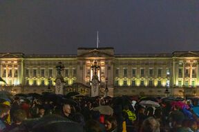 A crowd assembled outside of a large building