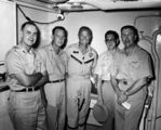 Medical debriefing of Major John H. Glenn, Jr., USMC after orbital flight of Friendship 7 on February 20, 1962 aboard the aircraft carrier يوإس‌إس Randolph (CVS-15). The debriefing team for Lt. Colonel Glenn (center) was led by Commander Seldon C. "Smokey" Dunn, MC, USN (FS) (RAM-qualified) (far right w/EKG in hands).