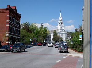 Main Street with storefronts and church in Middlebury, Vermont