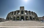 A large stone amphitheatre which is surrounded by many buildings.