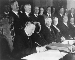 الرئيس الأمريكي كالڤن كولدج (يسار) يوقع الميثاق في يناير 1929، بواشنطن العاصمة.