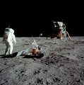 Aldrin stands next to the Passive Seismic Experiment Package with the Lunar Module in the background.