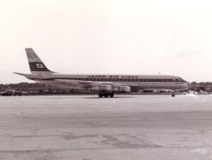 A black and white photograph of a Douglas DC-8 aircraft on the tarmac