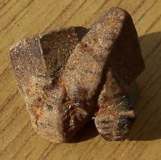 Intersecting twinned crystals of brown staurolite forming an abstract sculptural mass.