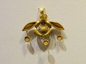 The Bee Pendant, an iconic Minoan jewel; 1700-1600 BC; gold; width: 4.6 cm; from Chrysolakkos (gold pit) complex at Malia; Archaeological Museum of Heraklion (Heraklion, Greece)[30][31]