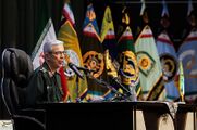 Mohammad Bagheri speaking with the Islamic Republic and military flags at the background.