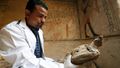 عالم آثار مصري يمسك بنسر محنط عثر عليه في مقبرة توتو.
