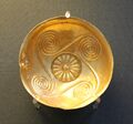 Embossed gold cup with a rosette and spirals