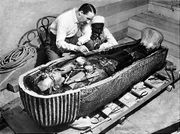 هوارد كارتر يفحص تابوت الفرعون توت عنخ آمون. بالمقبرة KV62 بالقرب من الأقصر، 1923
