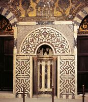 Mihrab of the mausoleum of Baybars, with marble mosaic paneling and glass mosaics above.