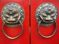 A traditional red Chinese door with Imperial guardian lion knocker.