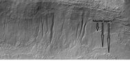Gullies and layers in mantle on a wall, as seen by HiRISE under HiWish program. Location is Eridania quadrangle.